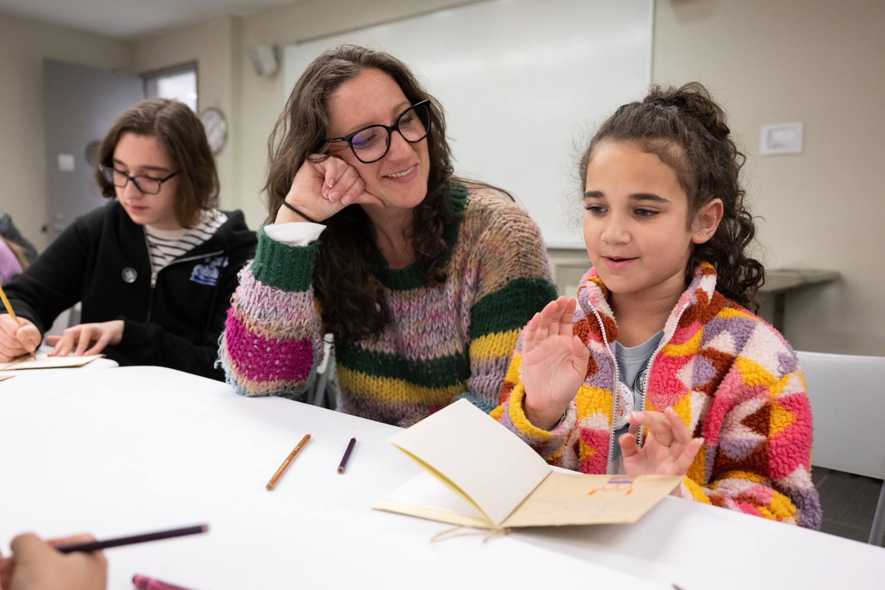 Three people of different ages enjoy an art making activity together.